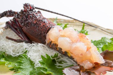 Istakoz ve diğer deniz ürünleriyle dolu bir tabak yemek.