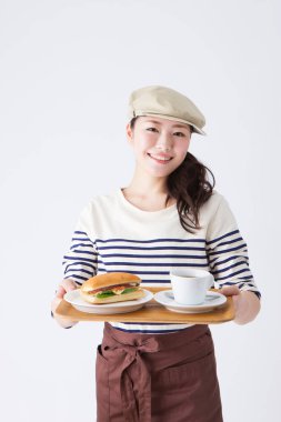 Neşeli Japon garson stüdyoda yemek servisi yapıyor.