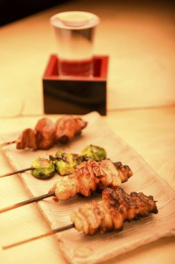 Lezzetli Asya yemeklerinin, et ve sebzelerin ahşap tahtadaki şişler üzerindeki görüntüsünü kapatın.