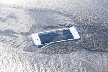 Deniz kıyısındaki kumsalda telefon