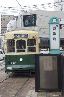 Gündüz vakti şehirde klasik yeşil tramvay 