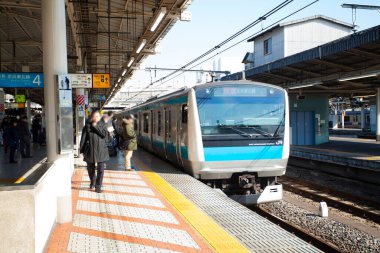 Modern yolcuların Japonya 'daki tren istasyonunda çekilmiş sokak fotoğrafı.