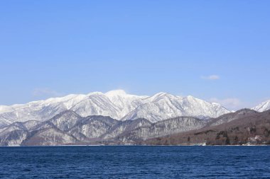 Karlı tepeleri ve gölü olan dağların manzarası 