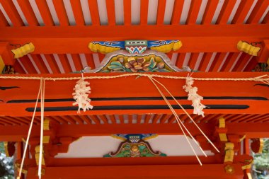 Renkli dekorasyon ve iplerle süslenmiş ahşap bir yapı.