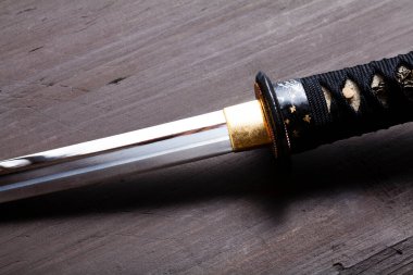 Yakından bakınca geleneksel Japon kılıcının tahta yüzeyde dinlendiğini görüyoruz.