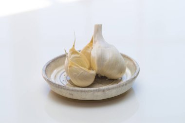 Beyaz bir masada bir kase sarımsak.