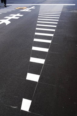 Asfalt kaldırımda beyaz yaya geçidi çizgileri