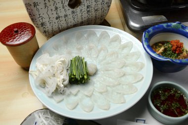 Tabağın ortasına yerleştirilmiş ince dilimlenmiş çiğ balık.