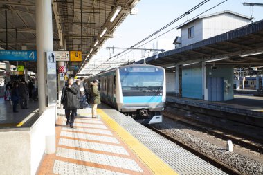 Modern yolcuların Japonya 'daki tren istasyonunda çekilmiş sokak fotoğrafı.