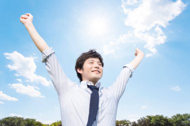 Parkta elini kaldırmış genç mutlu bir adam.