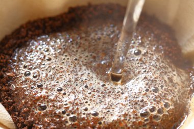 Kahve hazırlama sürecinin taze öğütülmüş kahve çekirdekleri ile yakın plan görüntüsü