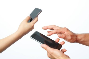Beyaz arka planda izole edilmiş akıllı telefonları tutan iki el. 