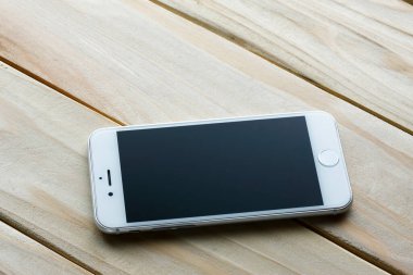 Ahşap masadaki akıllı telefon.