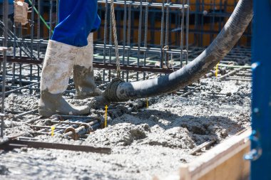 İnşaat alanında yer yapmak için çimento döken işçiler 