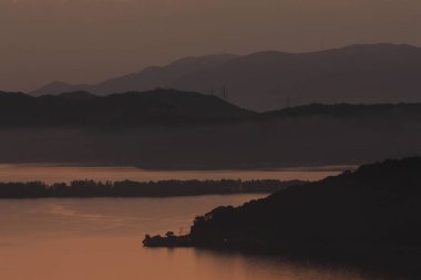 Göl ve dağların üzerinde güzel gün batımı 
