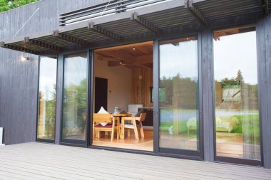 Büyük cam sürgülü kapıları olan modern bir ev.