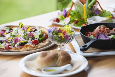 Lezzetli pizza ve sofrada çeşitli yemekler. 