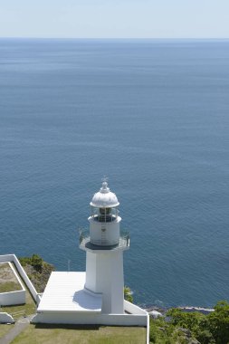 Yüksek açılı beyaz deniz feneri ve güzel deniz kıyısı manzarası      