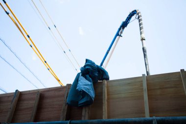 İnşaat alanı beton pompa ve ahşap bariyer gösteriyor