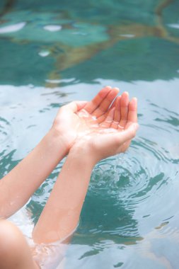 Japon onsen sıcak bahar banyosunda dinlenen bir kadının kırpılmış fotoğrafı.