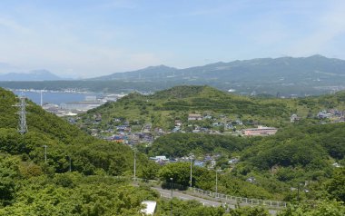 Yeşil tepeler, sahil kasabası ve okyanus körfezi manzarası 