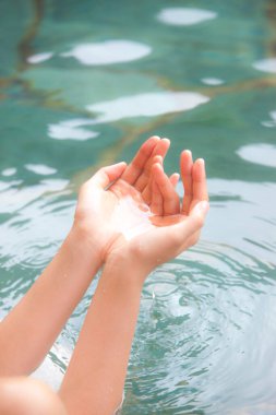 Japon onsen sıcak bahar banyosunda dinlenen bir kadının kırpılmış fotoğrafı.