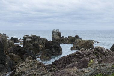 Kayalık kıyıları ve uçurumları olan güzel bir deniz manzarası                