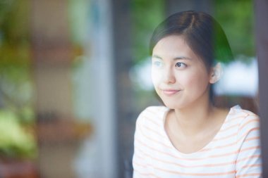 Kadın pencereye bakıyor. Yakından. 