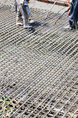 İşçiler inşaat alanında yer yapmak için çelik takviyesi kullanıyorlar. 