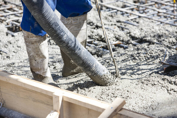рабочая заливка цемента для изготовления пола на строительной площадке 