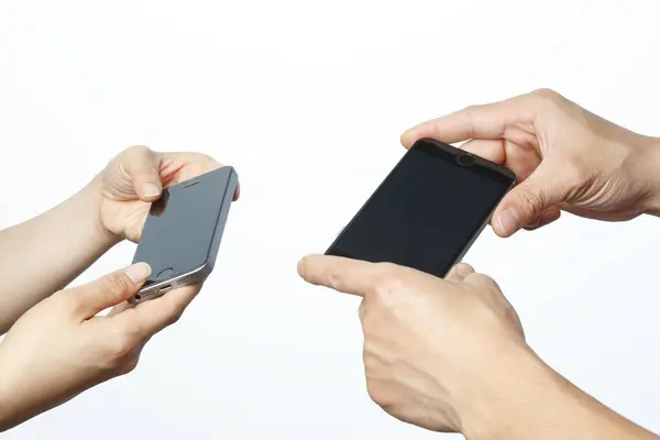 白い背景に隔離されたスマートフォンを保持する2つの手 — ストック写真