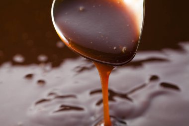 Kalın domates sosu kaşıktan akıyor. 