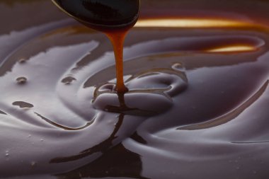 Kepçeden akan koyu siyah sos.