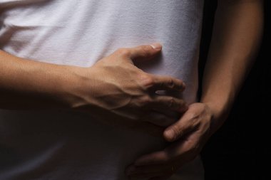 Karnını Ağrıyla veya Rahatsızlıkla Tutan Bir Kişinin Yakın Çekimi