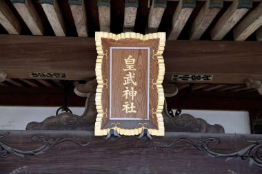 Tahta Japon tapınağı tabelasında altın dekoratif sınır yazıyor.