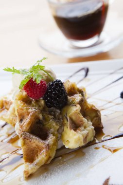 Beyaz masada ahududu ve yaban mersinli waffle, lezzetli bir tatlı.