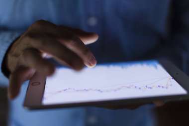 Tablet ekranında gösterilen mali istatistikleri analiz eden iş adamının yakın görüntüsü