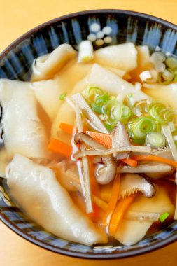 Tahta masadaki Wonton eriştelerinin yakın plan görüntüsü.