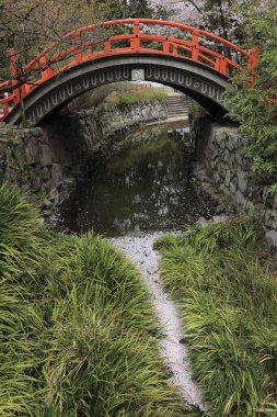 Küçük nehrin üzerinde köprüsü olan güzel bir bahar parkı manzarası.