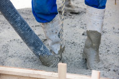 İnşaat alanında yer yapmak için çimento döken işçiler 