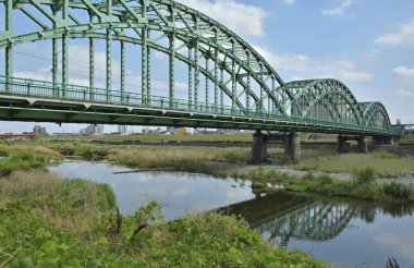 Nehir ve şehir üzerindeki modern çelik köprü ufukta ufuk çizgisi
