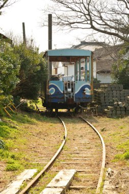 Tren gündüz vakti köyde raylarda hareket ediyor. 
