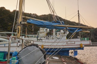 Gün batımında limandaki eski tekne. 