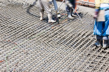 İşçiler inşaat alanında yer yapmak için çelik takviyesi kullanıyorlar. 