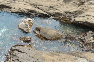 Güzel kayalık deniz kıyıları, sudaki taşlarla