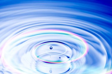 Renkli arkaplanlı mavi su damlası