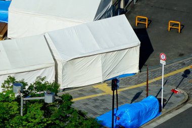 Gündüz vakti sokağın köşesindeki kaldırımları kaplayan beyaz çadırlar