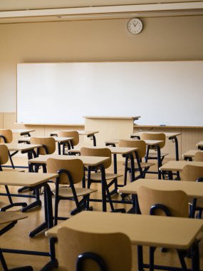 Okul sınıfında boş karatahta, masa ve sandalyeler 