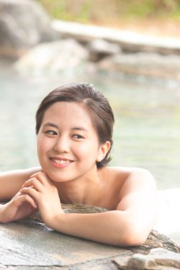 Genç bayan Japon onsen sıcak bahar banyosunda dinleniyor.