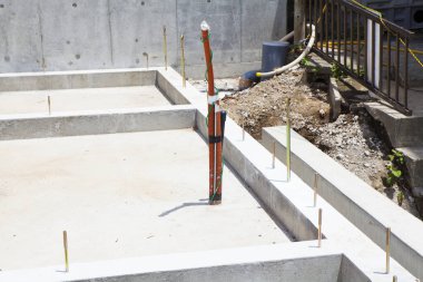 İnşaat alanı beton temeli ve tesisat borularını gösteriyor